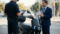 Agente de trânsito observando uma scooter elétrica moderna em uma blitz urbana, com o proprietário segurando o capacete e conversando com um advogado de terno.