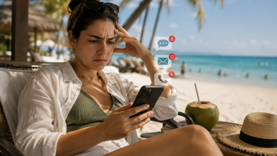 Mulher sentada em uma cadeira de praia durante as férias, olhando preocupada para o celular enquanto recebe diversas notificações de mensagens, e-mails e ligações de trabalho. Ao fundo, o cenário paradisíaco contrasta com a expressão de preocupação, simbolizando a dificuldade de se desconectar da empresa durante o período de descanso.